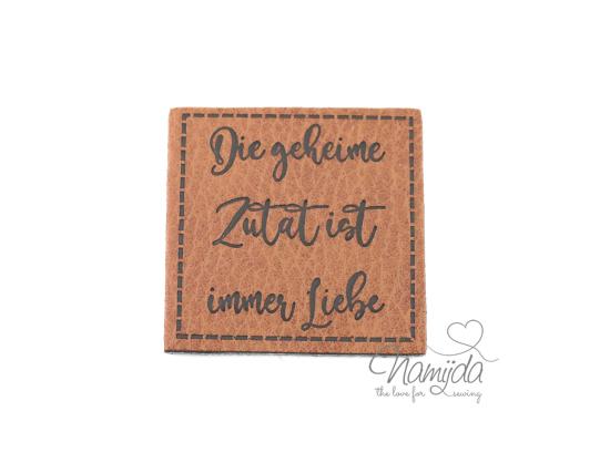 1 Stück - XL KuNSTLEDER LABEL DIE GEHEIME ZUTAT IST IMMER LIEBE - AUFNÄHER MIT VORGEDRUCKTER NÄHNAHT - 40mm x 40mm