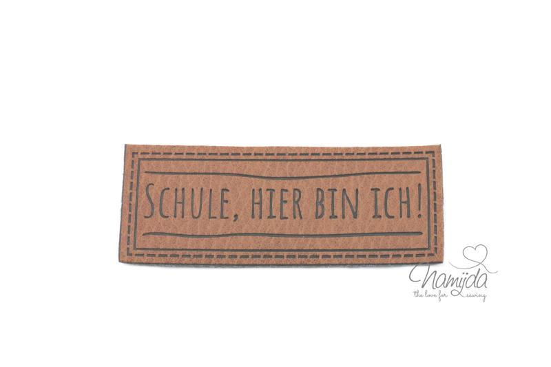 1 Stück - XL KuNSTLEDER LABEL SCHULE; HIER BIN ICH! - AUFNÄHER MIT VORGEDRUCKTER NÄHNAHT - 60mm x 25mm